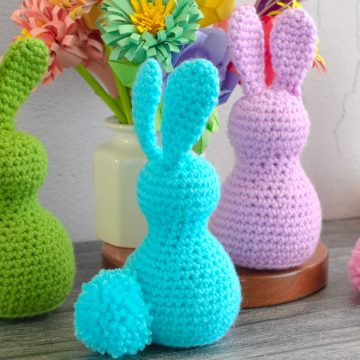 A blue crochet bunny with a pom-pom tail.