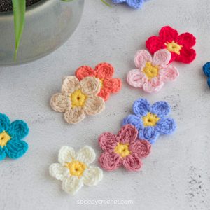 Five petal crochet flowers in different colors.