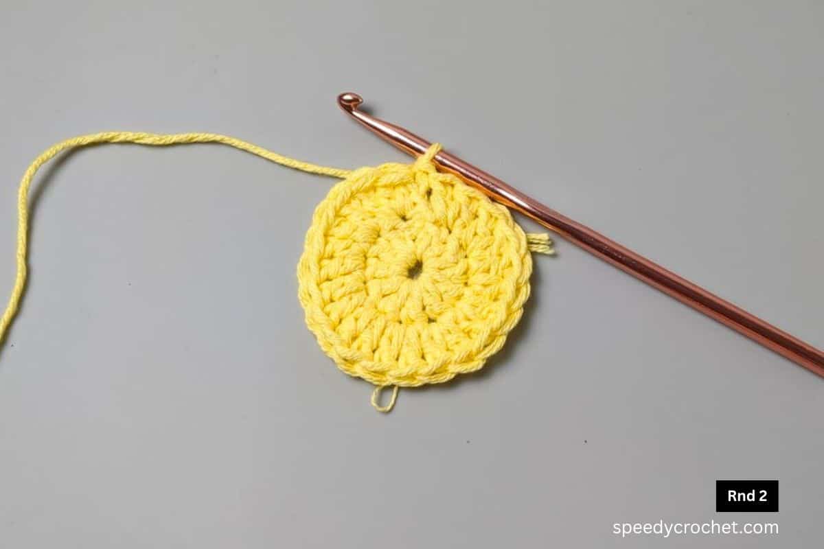 A yellow two round crocheted circle.