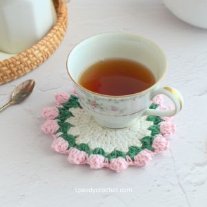 A cup on a pink and white coaster.