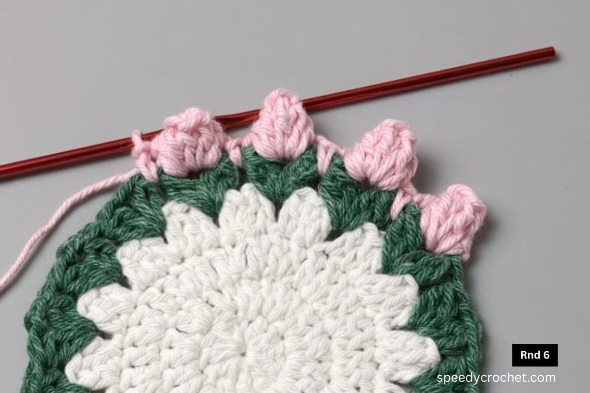 A rosebud round on a crochet coaster.