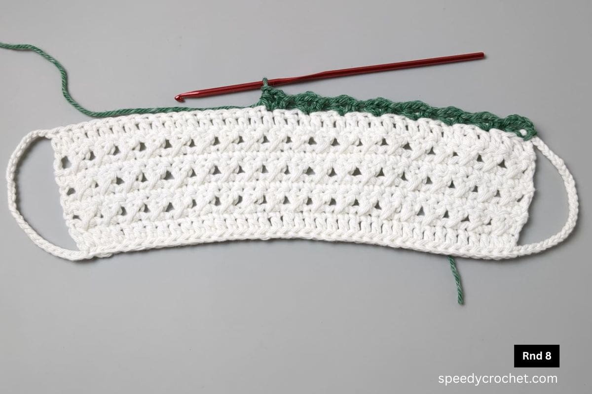 A green crochet row on top of white crochet rows.