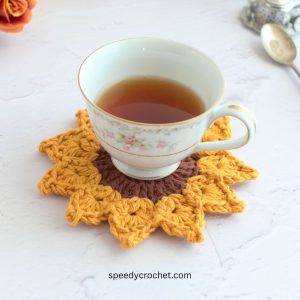 A sunflower coaster with a tea cup on top.