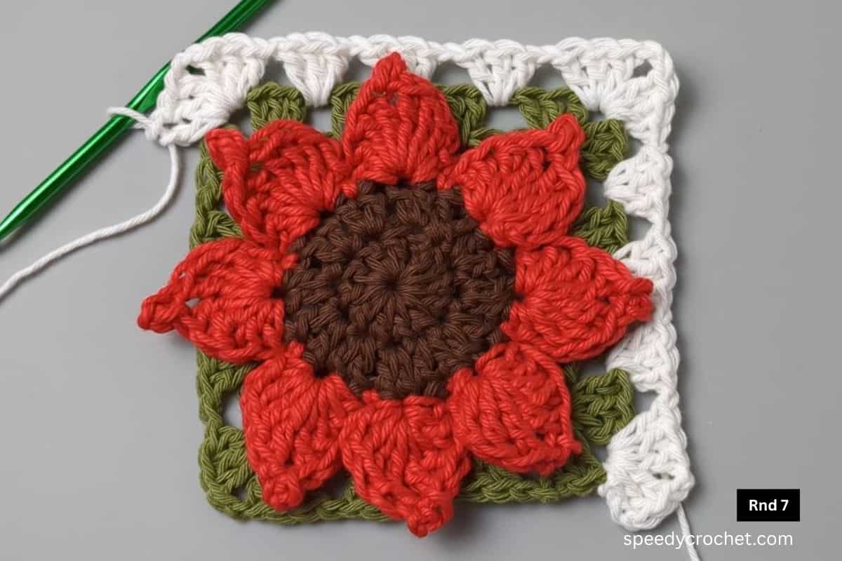 A sunflower granny square with a white border.