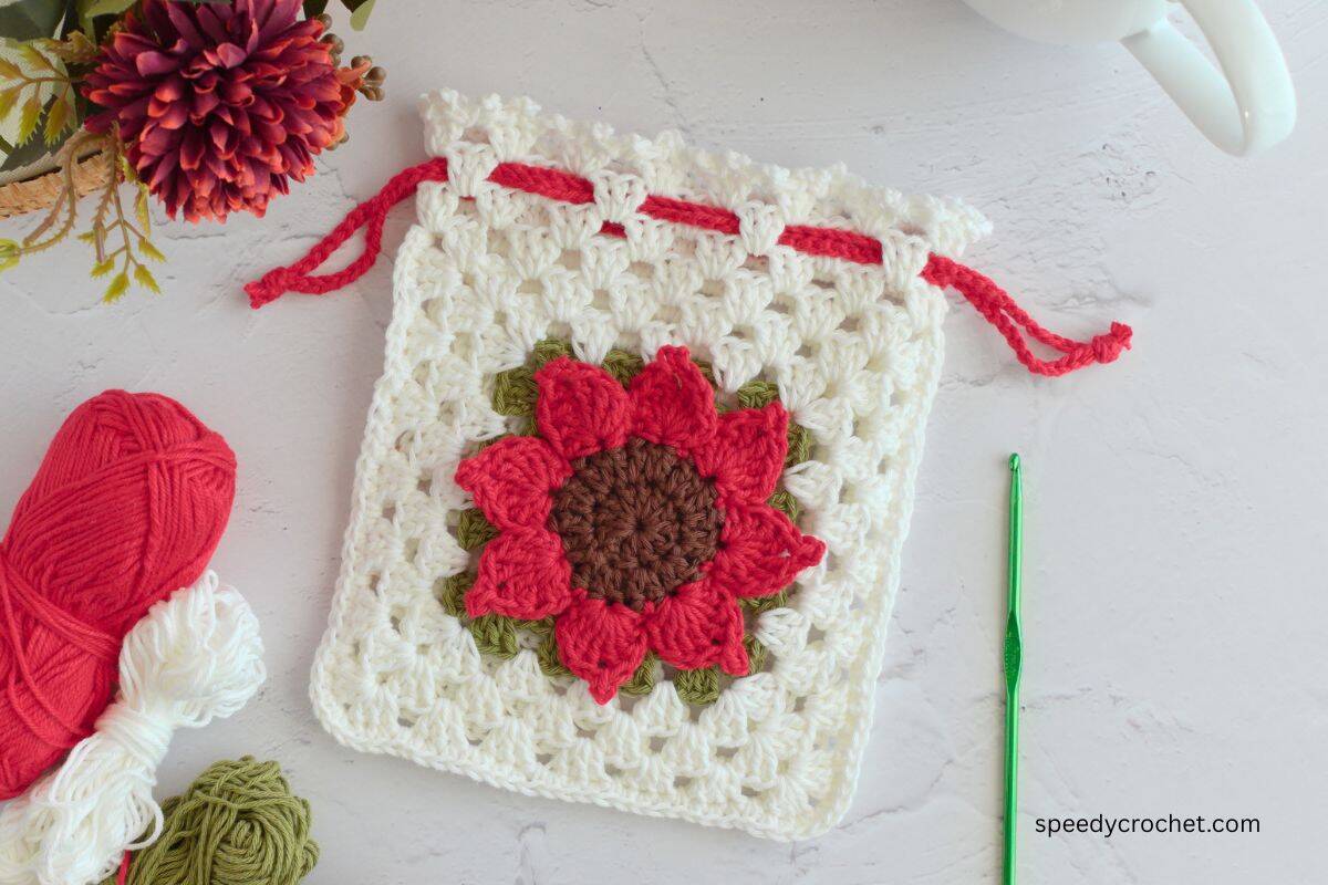 A red sunflower crochet pouch.