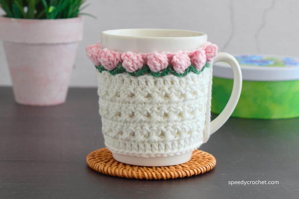 A Pink and white mug cozy on a mug.
