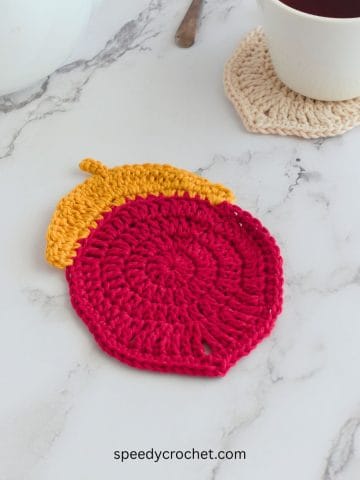 Red and gold crochet acorn coaster.