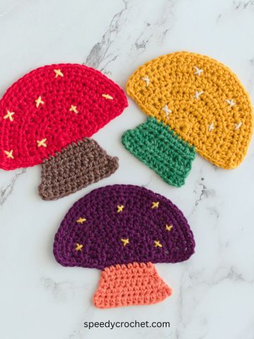 Three crochet mushroom coasters.