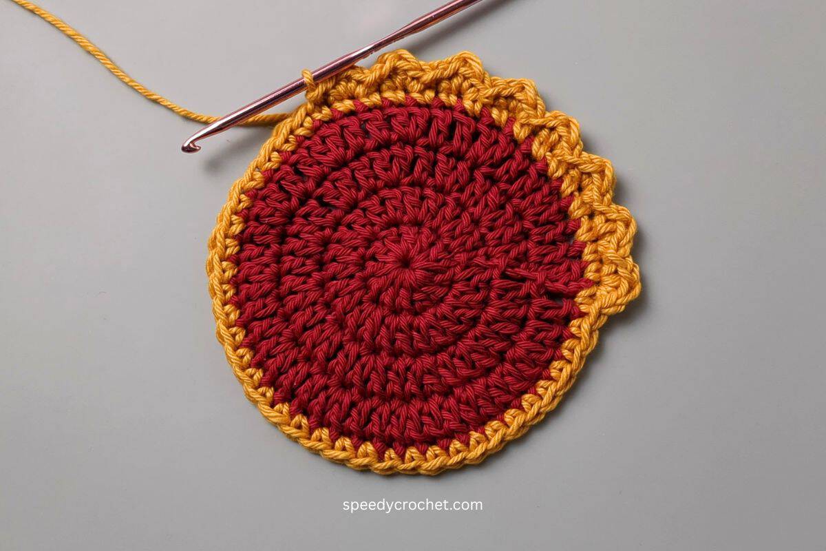 A crochet circle with gold edging.